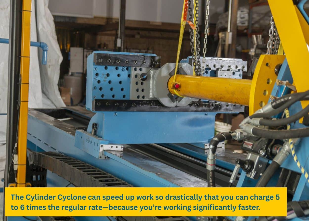 Hydraulic cylinder being secured on a blue repair bench with yellow lifting equipment and multiple hoses attached during servicing. Caption: The Cylinder Cyclone can speed up work so drastically that you can charge 5 to 6 times the regular rate—because you’re working significantly faster.