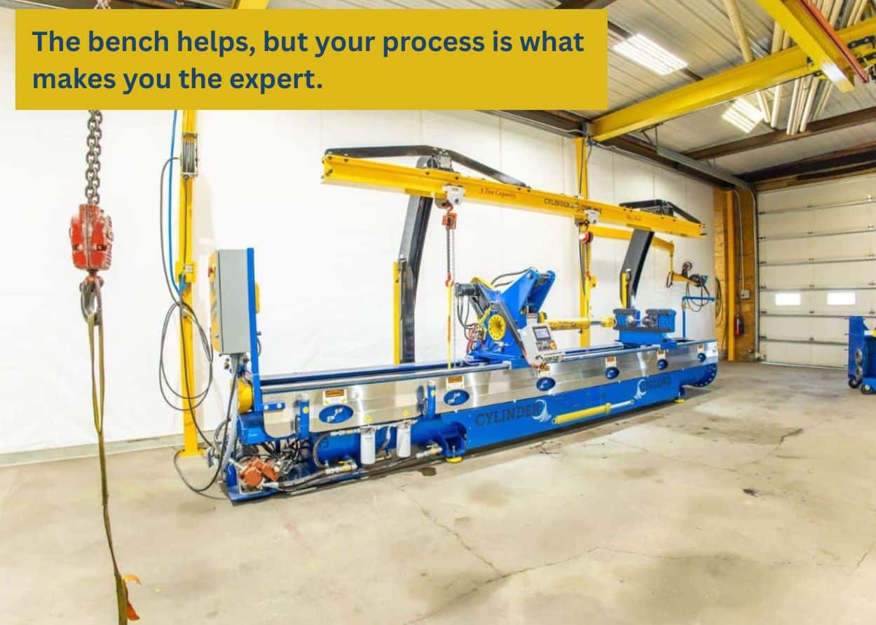 Full hydraulic cylinder repair bench system inside industrial shop lifting and servicing large excavator cylinders safely.
