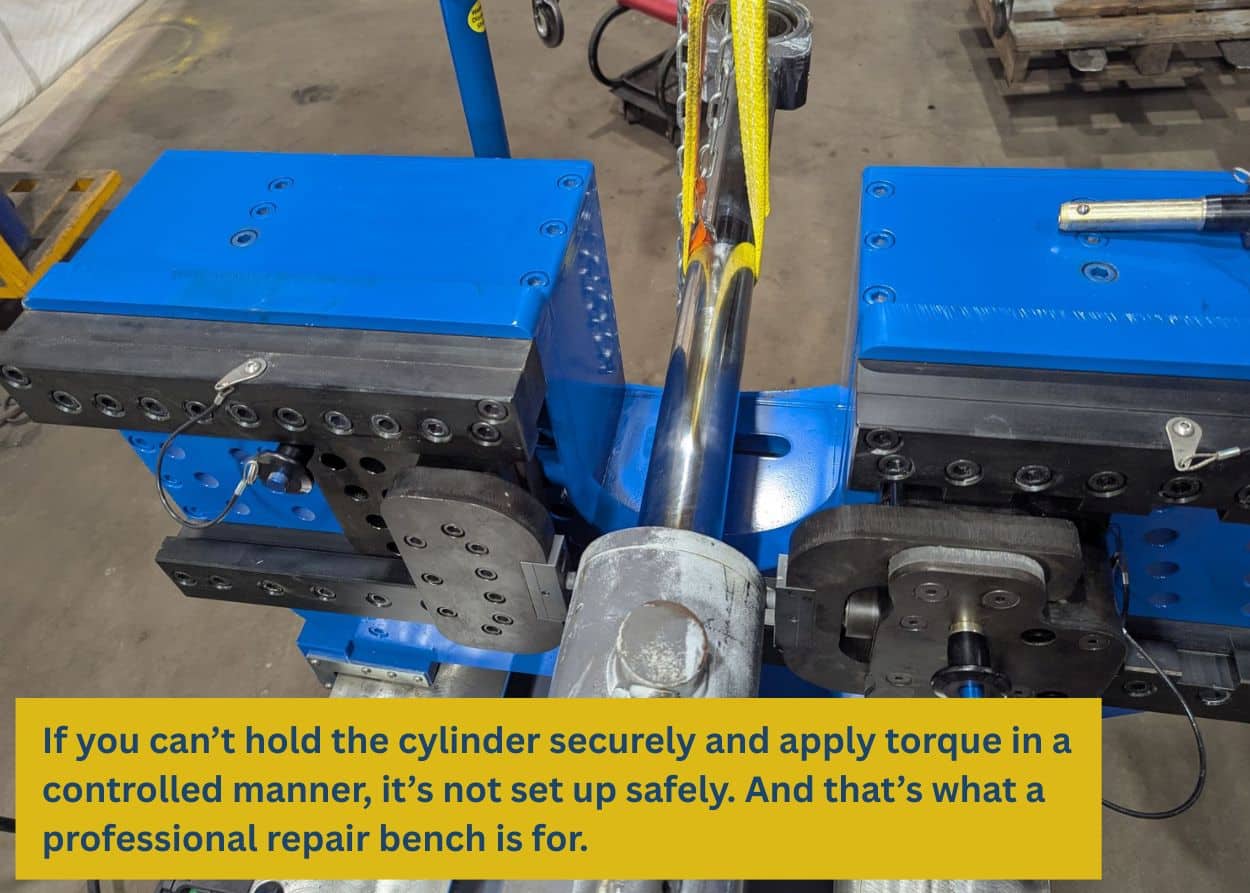 Hydraulic cylinder clamped securely in a heavy-duty repair bench designed for excavator cylinder disassembly and reassembly.